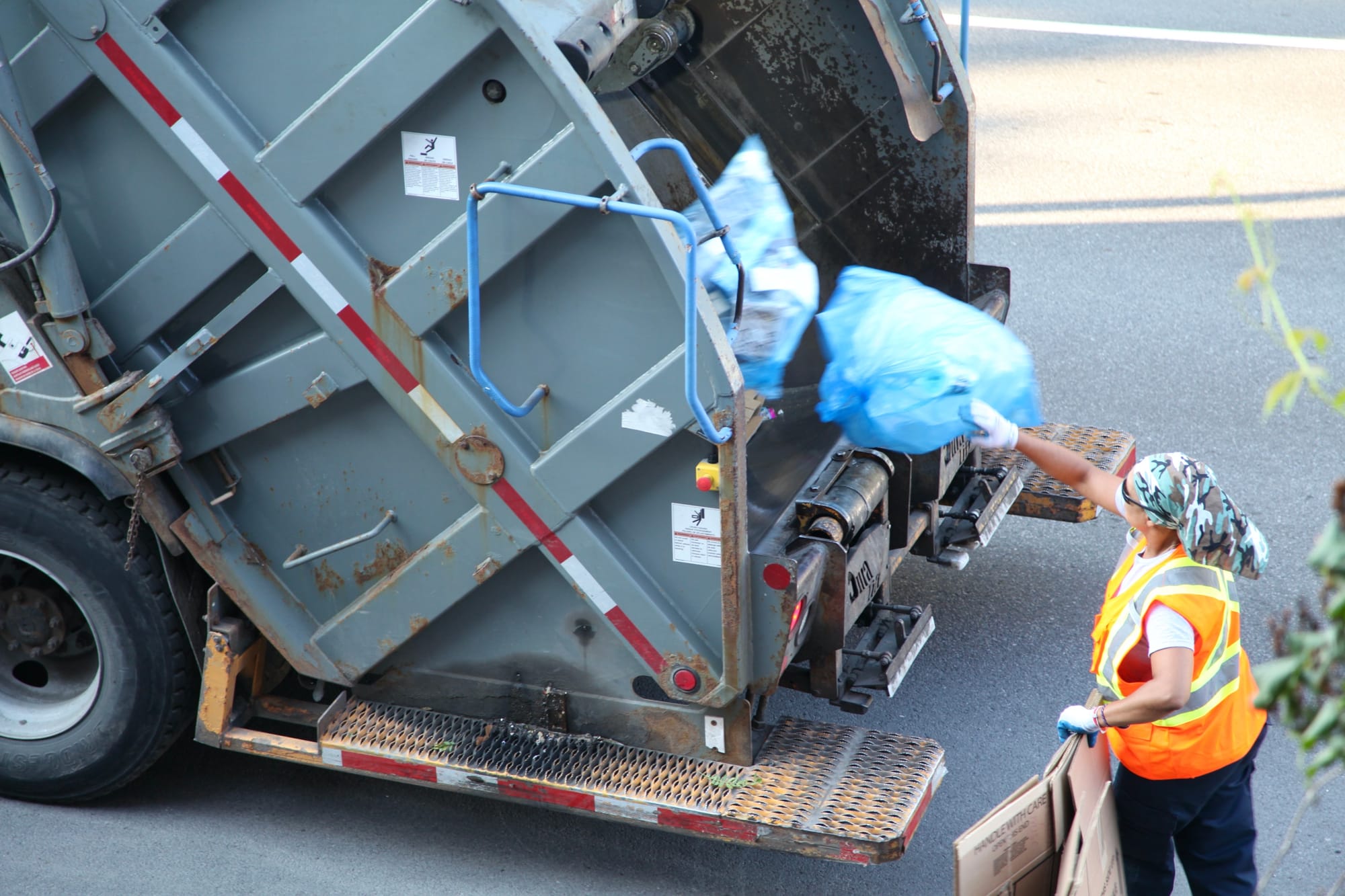 Un humain lance un sac de récupération dans un camion. 