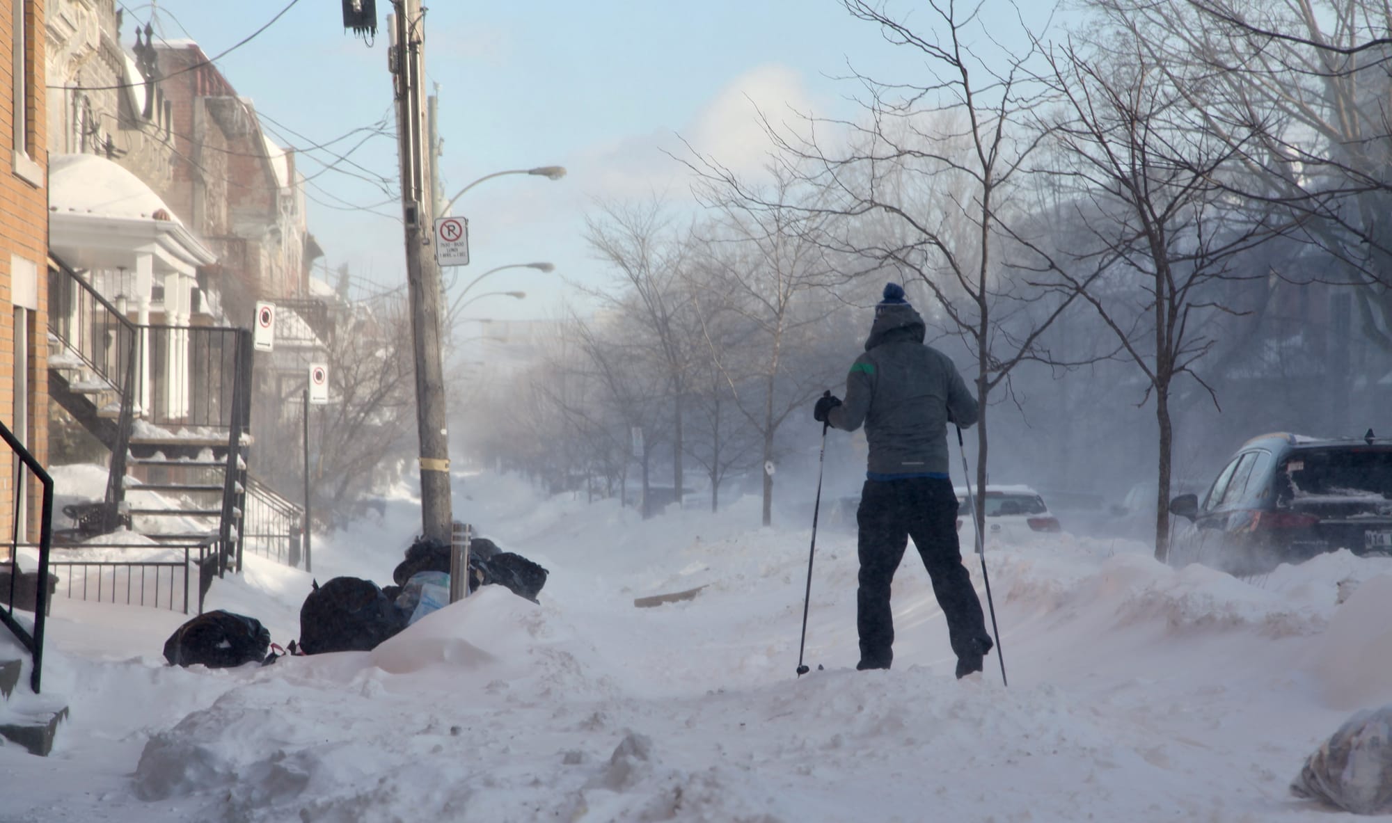 Un homme, profitant de l'abondance de neige, se déplace en skis de fond.